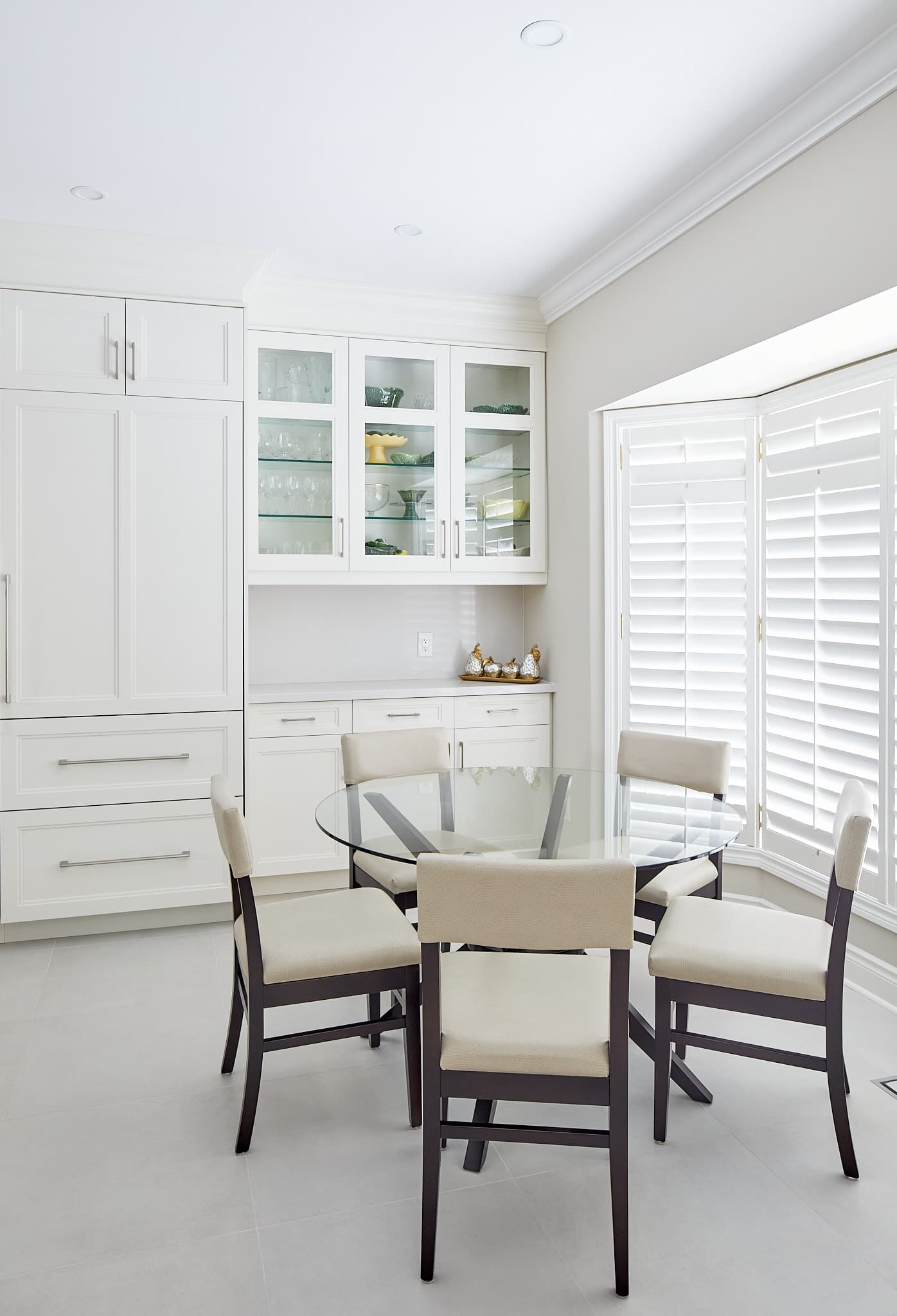 Kitchen dining area with glass-front cabinetry by Harbour Kitchens